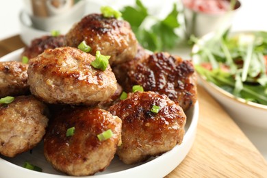 Photo of Delicious patties with green onions on table, closeup