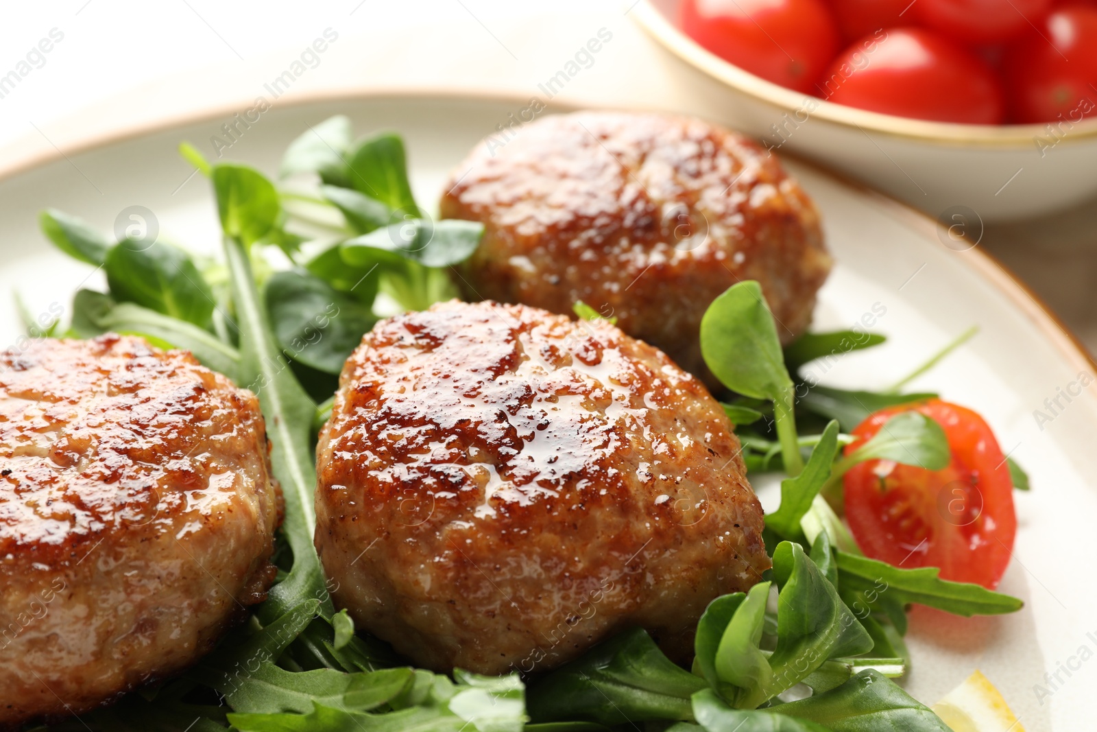 Photo of Delicious patties with greens and tomato on table, closeup