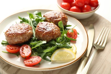 Photo of Delicious patties with greens, tomatoes and cutlery on table, closeup