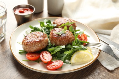 Photo of Delicious patties with greens, tomatoes, ketchup and drink on wooden table, closeup