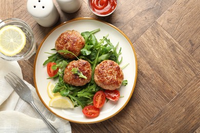 Photo of Delicious patties with greens, tomatoes, ketchup and drink on wooden table, flat lay. Space for text