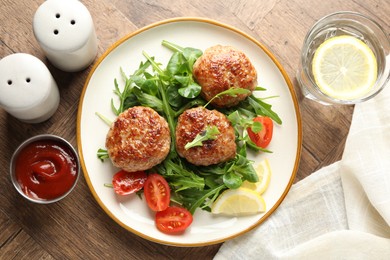 Photo of Delicious patties with greens, tomatoes, ketchup and drink on wooden table, flat lay