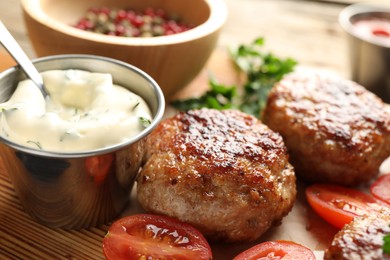 Photo of Delicious patties with sauce and tomatoes on table, closeup