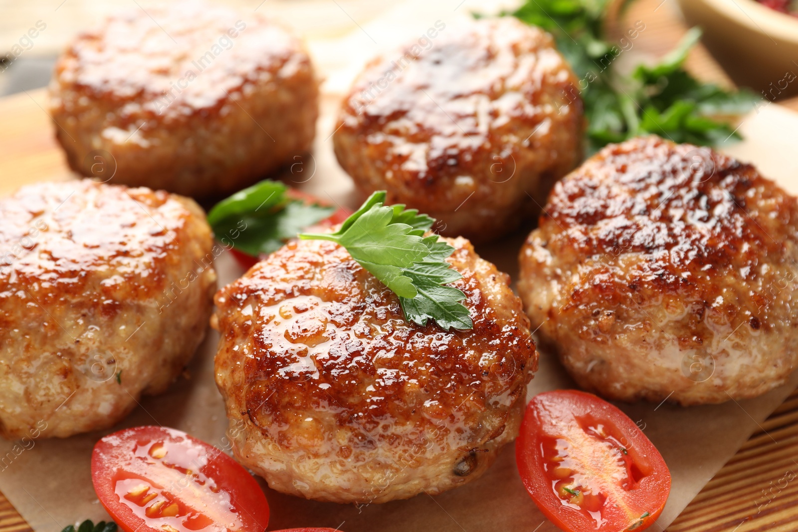 Photo of Delicious patties with parsley and tomato on table, closeup