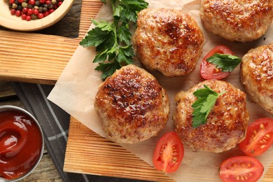 Photo of Delicious patties, spices, tomatoes and ketchup on table, flat lay