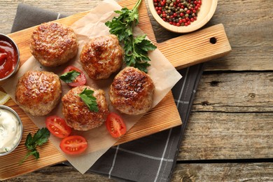 Photo of Delicious patties served on wooden table, flat lay. Space for text