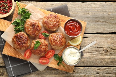 Photo of Delicious patties served on wooden table, flat lay. Space for text