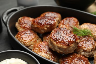 Photo of Delicious patties in baking dish on table, closeup