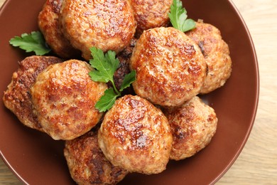 Photo of Delicious patties with parsley on wooden table, top view