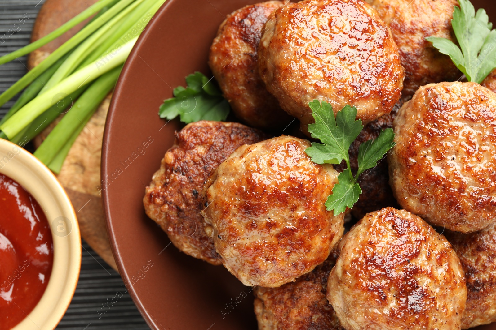 Photo of Delicious patties and spices on black textured table, flat lay