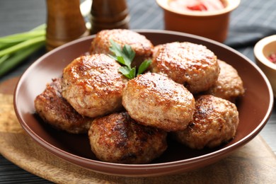 Photo of Delicious patties with parsley on table, closeup