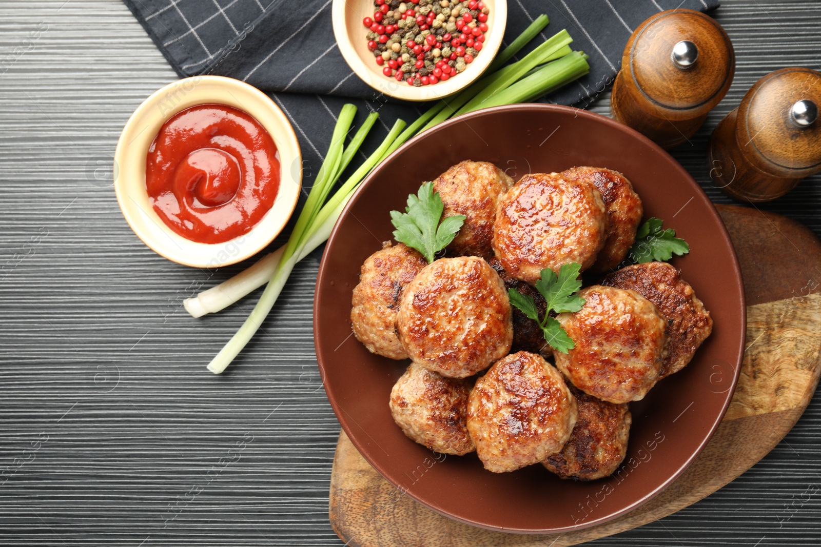 Photo of Delicious patties and spices on black textured table, flat lay. Space for text