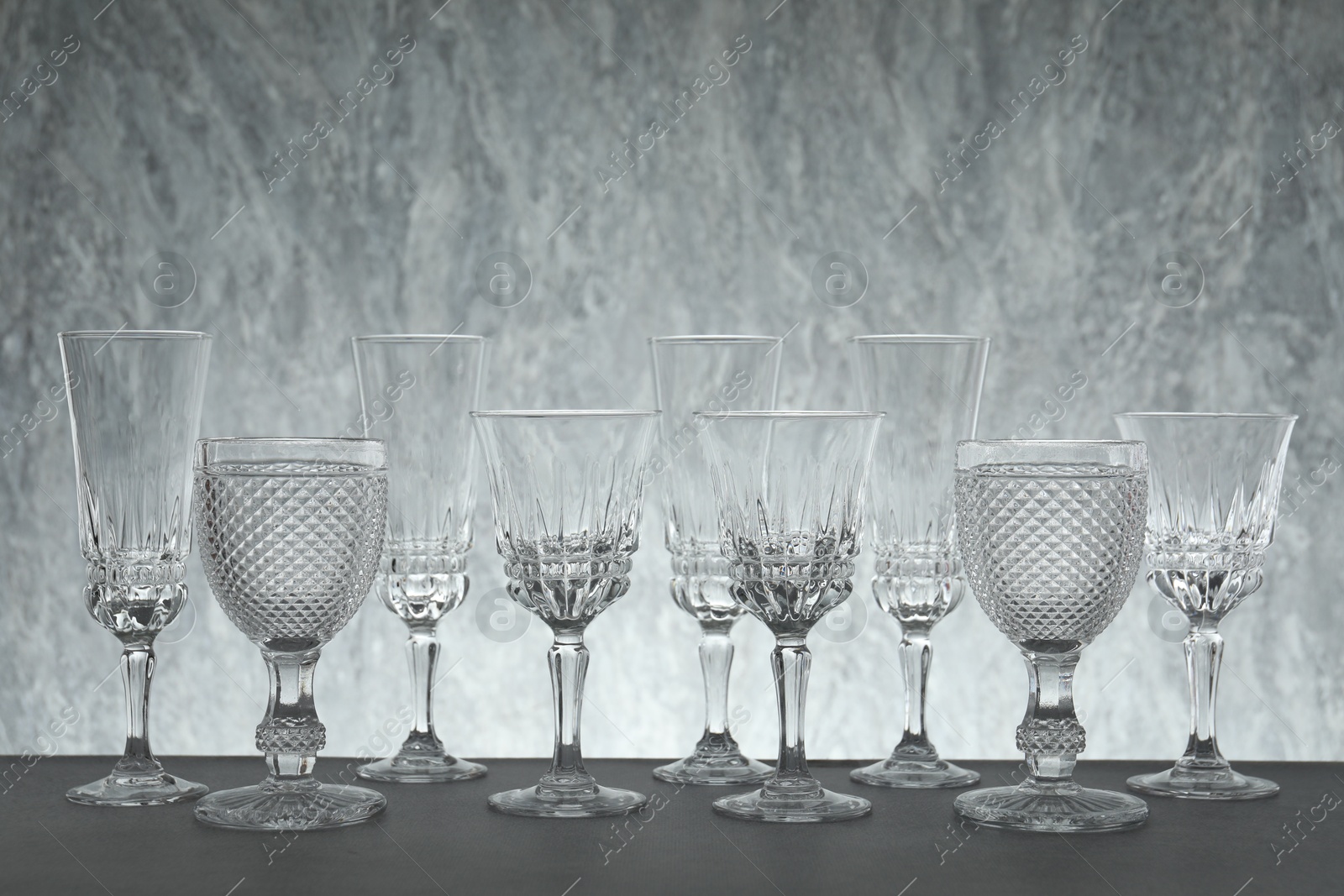 Photo of Many empty clean glasses on grey table