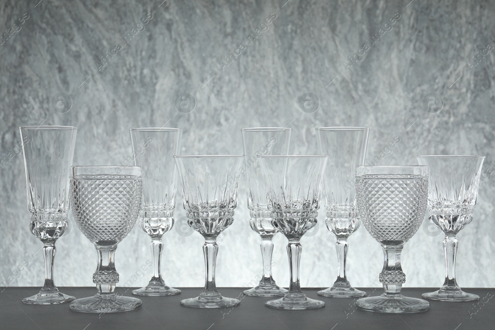 Photo of Many empty clean glasses on grey table