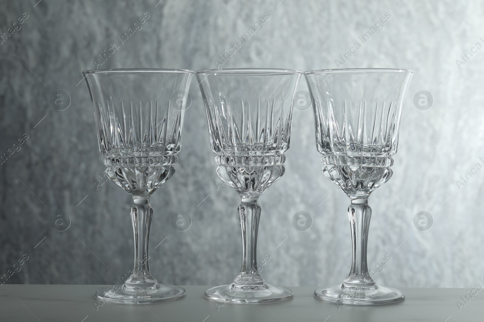 Photo of Three empty clean glasses on grey table