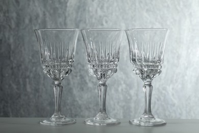 Photo of Three empty clean glasses on grey table