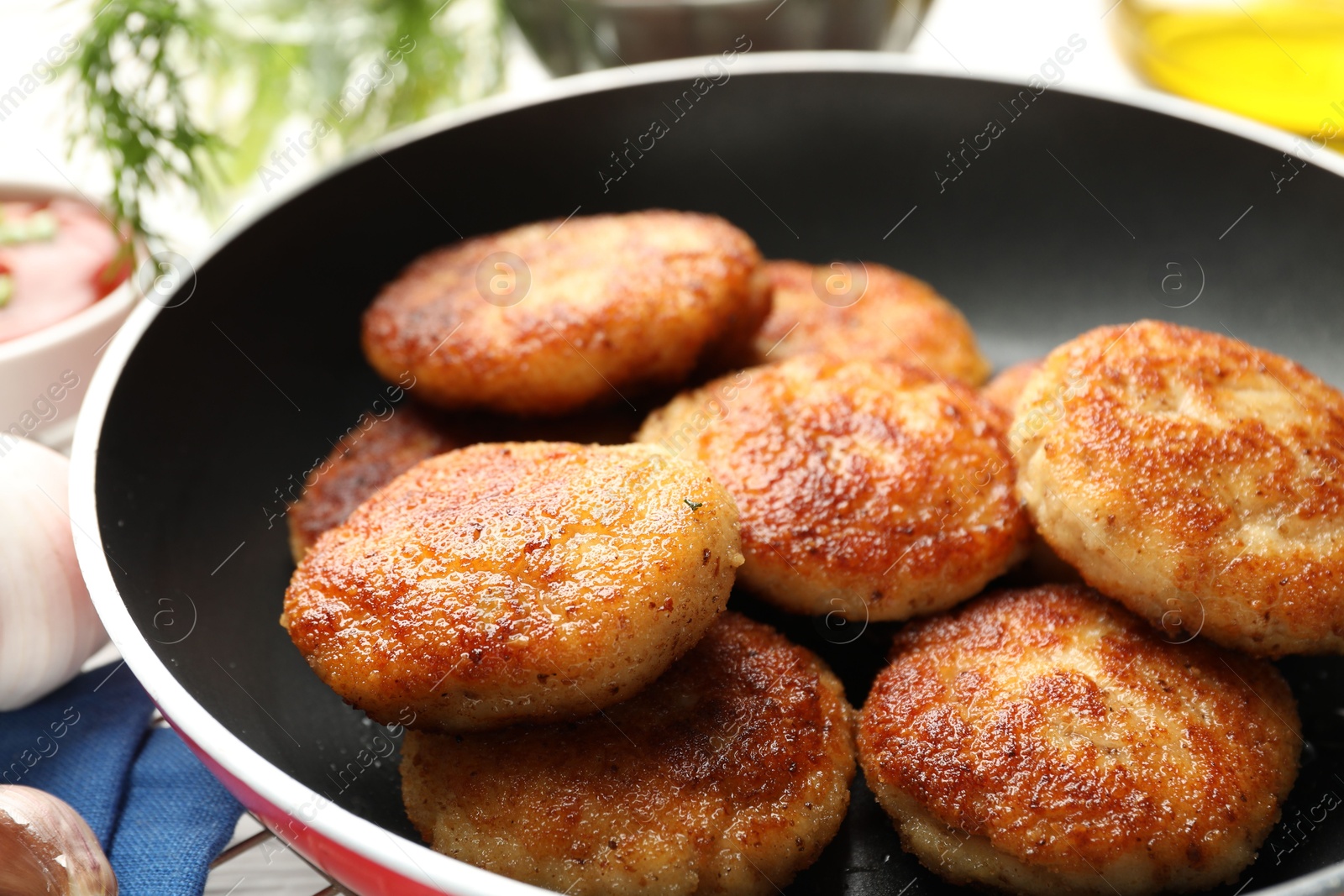 Photo of Delicious patties in frying pan on table, closeup