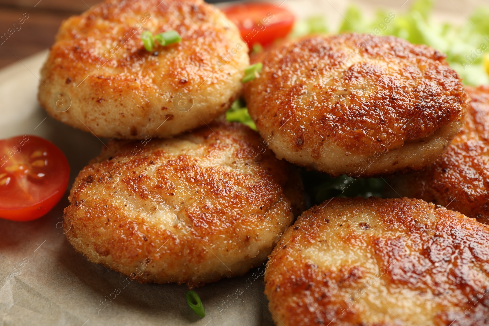 Photo of Delicious patties with green onions and tomato on table, closeup