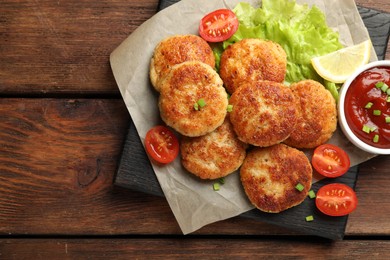 Photo of Delicious patties served on wooden table, top view. Space for text