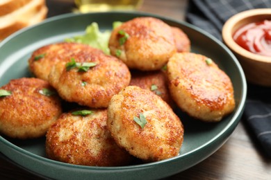 Photo of Delicious patties, parsley and ketchup on table, closeup