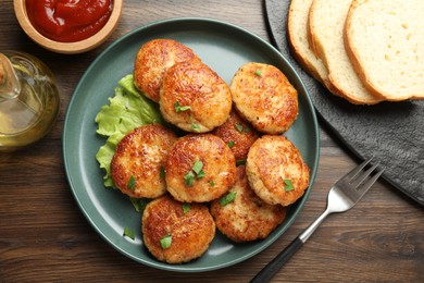 Photo of Delicious patties served on wooden table, flat lay