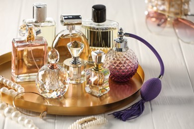 Photo of Different luxury perfumes on white wooden table