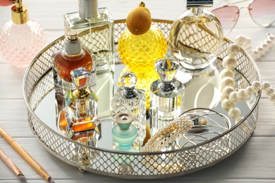 Photo of Different luxury perfumes on white wooden table