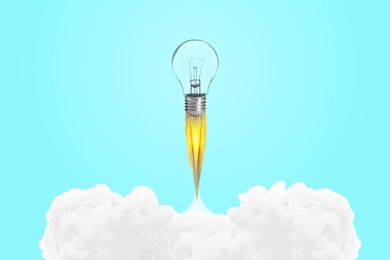 Image of Light bulb soaring up like rocket with smoke and fire on light blue background. Concepts of idea, startup, creativity, fast success