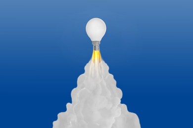 Image of Light bulb soaring up like rocket with smoke and fire on blue gradient background. Concepts of idea, startup, creativity, fast success