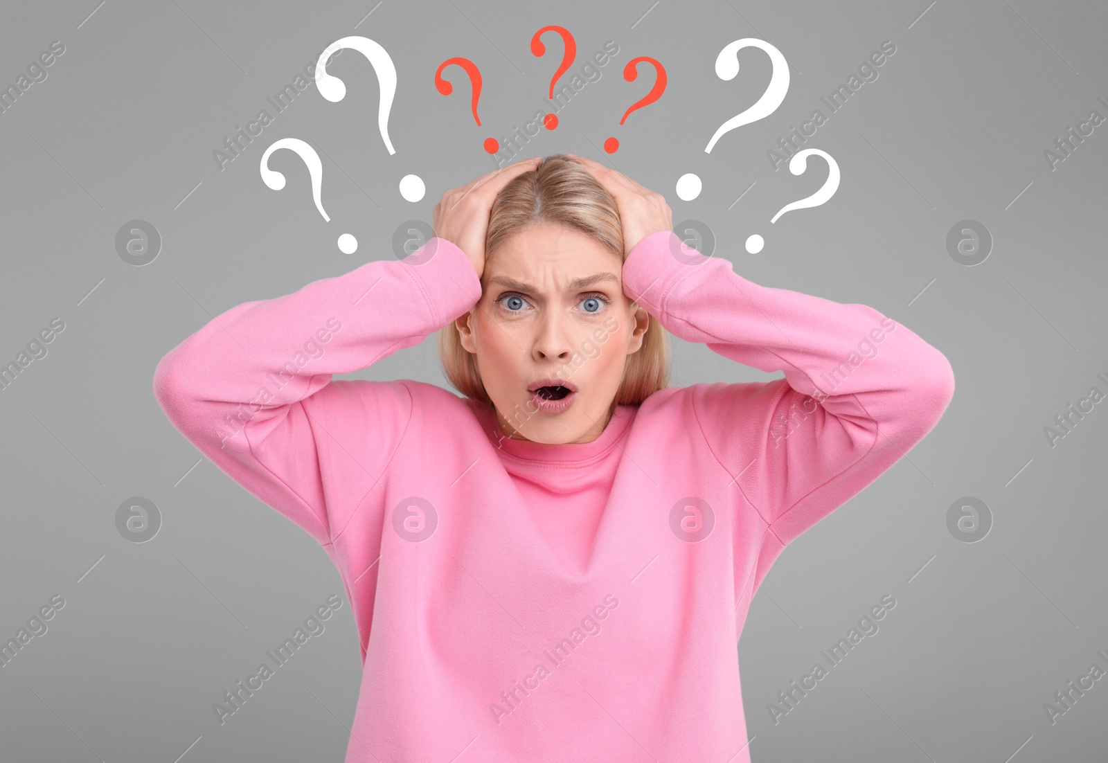 Image of Question marks over shocked woman on grey background