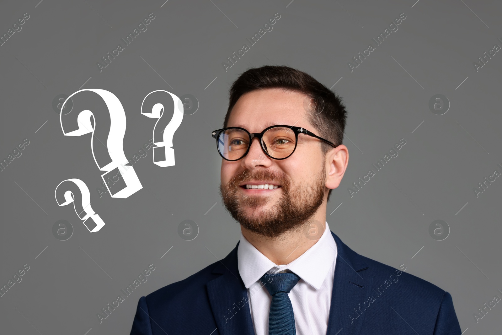 Image of Happy businessman looking at question marks on grey background