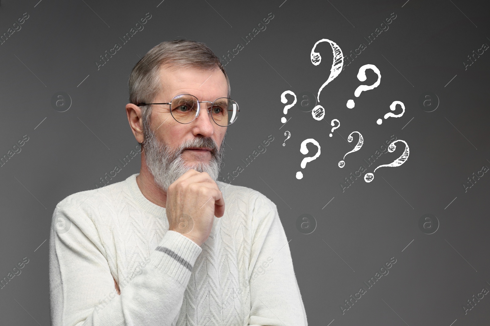 Image of Thoughtful senior man on grey background. White question marks near him