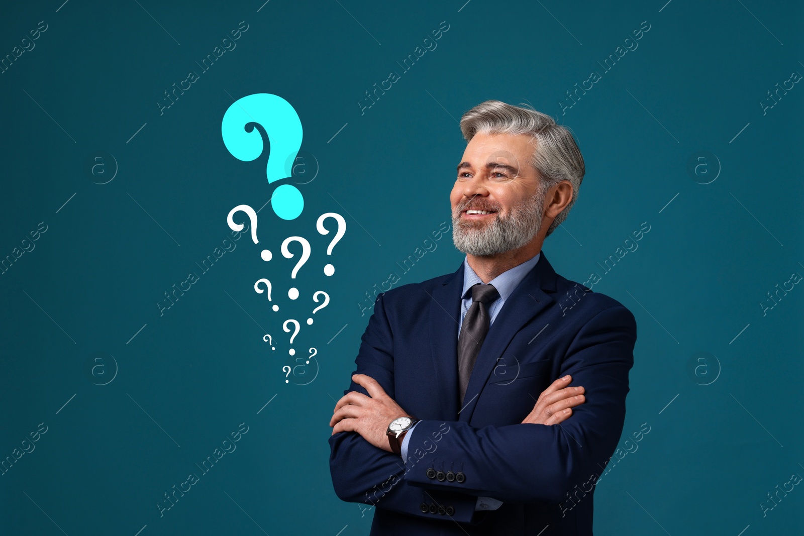 Image of Happy businessman looking at question marks on teal color background