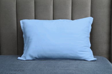 Image of Pillow in light blue color on bed, closeup