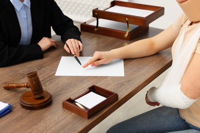 Photo of Injured woman having meeting with lawyer in office, closeup