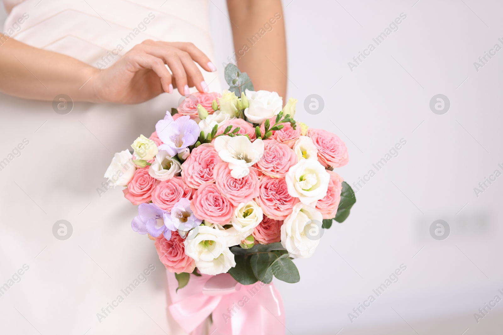 Photo of Bride with beautiful wedding bouquet on light background, closeup. Space for text