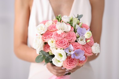 Photo of Bride with beautiful wedding bouquet on light background, closeup