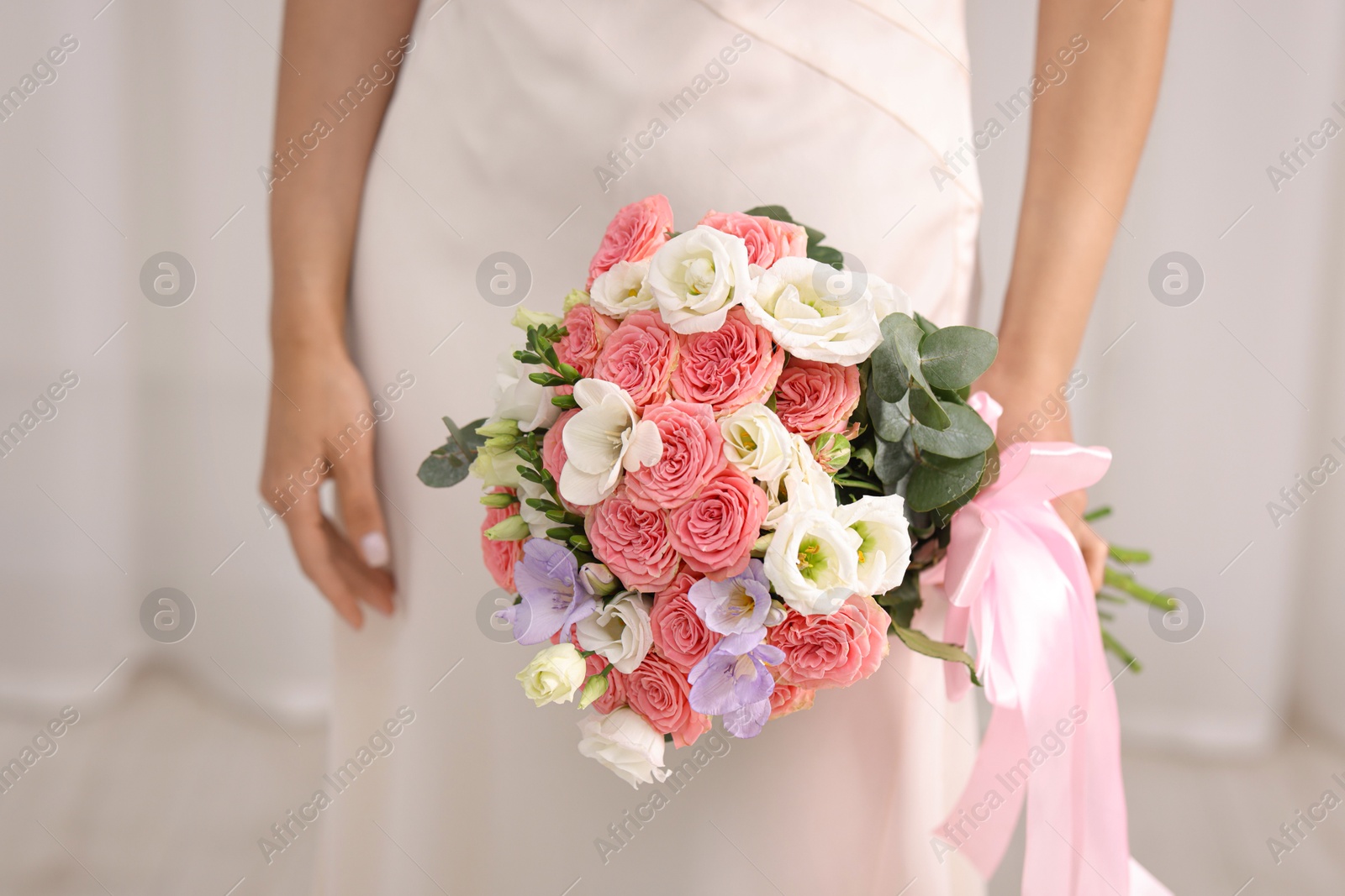 Photo of Bride with beautiful wedding bouquet on light background, closeup