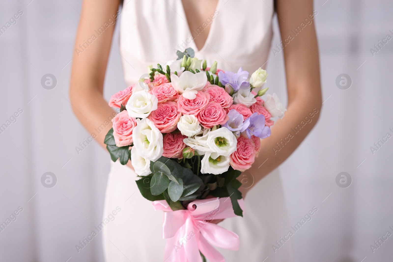 Photo of Bride with beautiful wedding bouquet on light background, closeup