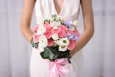 Photo of Bride with beautiful wedding bouquet on light background, closeup