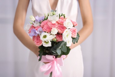 Photo of Bride with beautiful wedding bouquet on light background, closeup