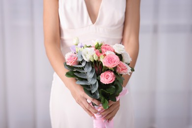 Photo of Bride with beautiful wedding bouquet on light background, closeup