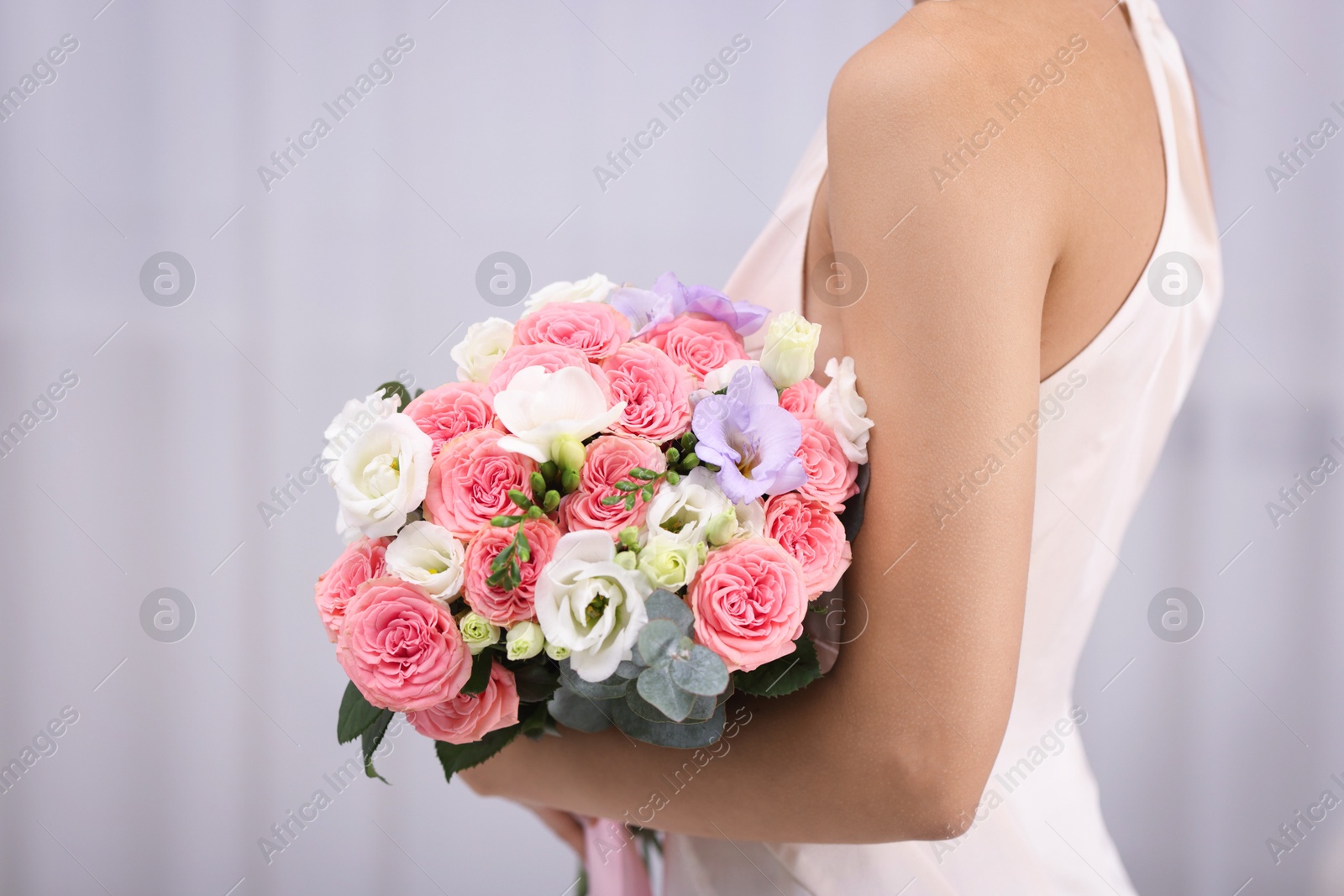 Photo of Bride with beautiful wedding bouquet on light background, closeup. Space for text