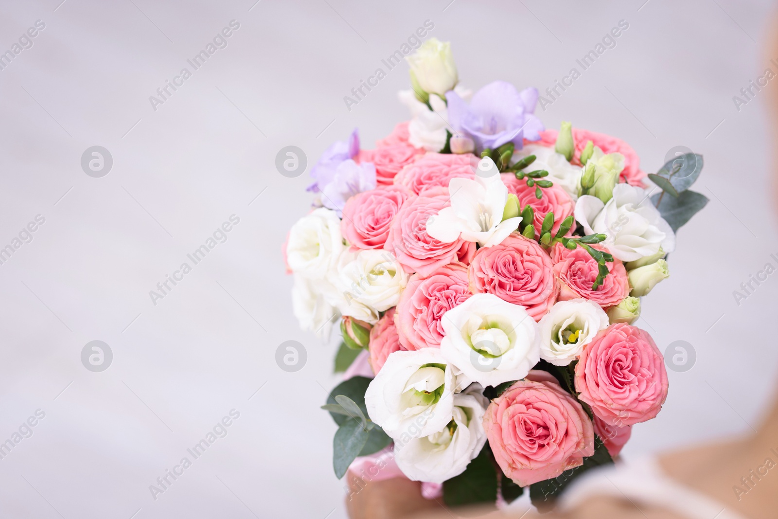 Photo of Bride with beautiful wedding bouquet on light background, closeup. Space for text