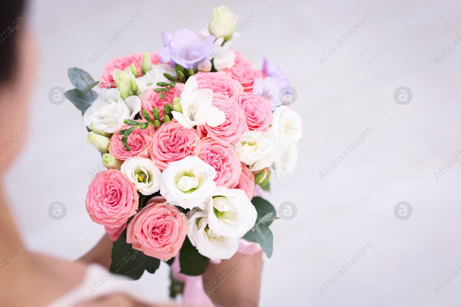 Photo of Bride with beautiful wedding bouquet on light background, closeup. Space for text