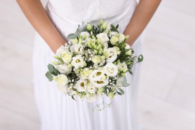 Photo of Bride with beautiful wedding bouquet on light background, closeup