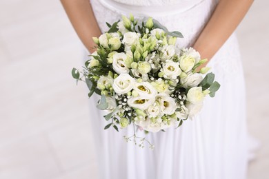 Photo of Bride with beautiful wedding bouquet on light background, closeup. Space for text