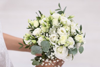 Photo of Bride with beautiful wedding bouquet on light background, closeup