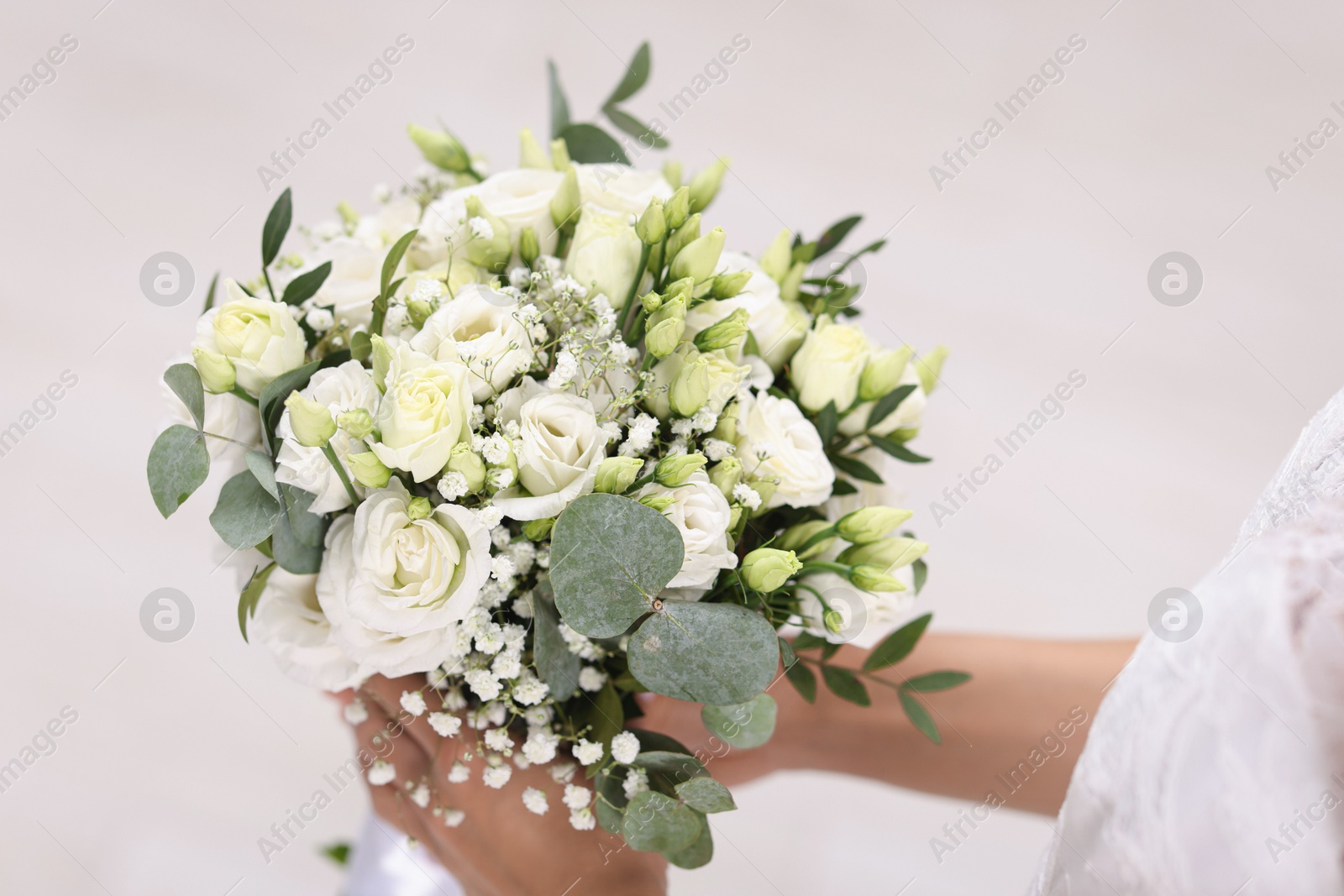 Photo of Bride with beautiful wedding bouquet on light background, closeup