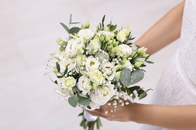 Photo of Bride with beautiful wedding bouquet on light background, closeup